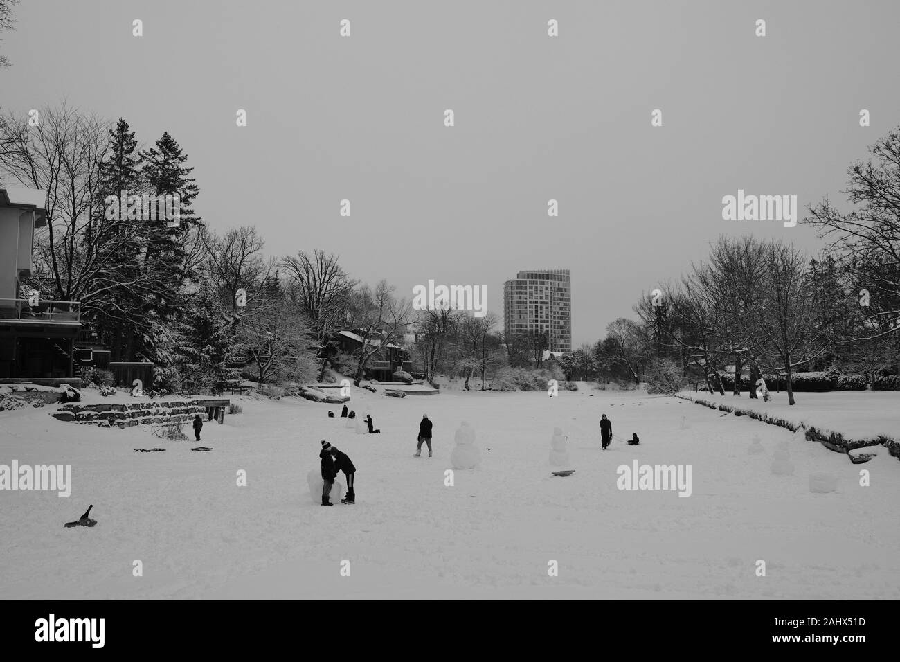 Como una pintura Lowry - foto en blanco y negro y tobogganers snowmen decisiones en Brown's Inlet, Ottawa, Ontario, Canadá. Foto de stock