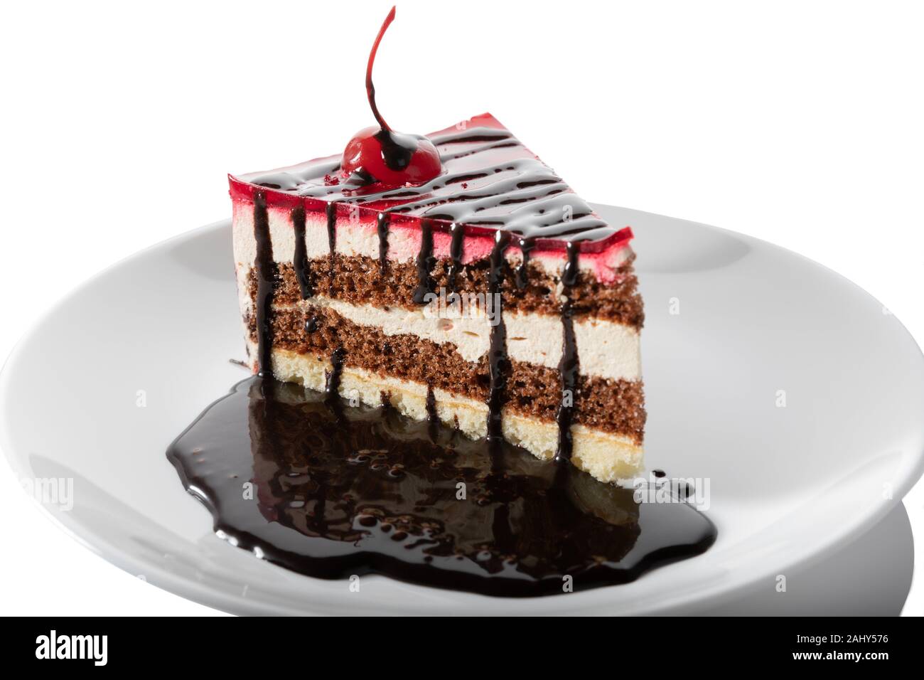 Sabroso pastel de chocolate con topping aislado sobre fondo blanco. Foto de stock