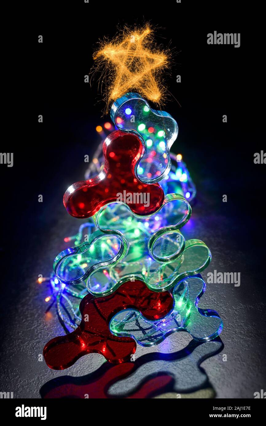 Un árbol de Navidad compuesto de formas plásticas y las luces de hadas Foto de stock