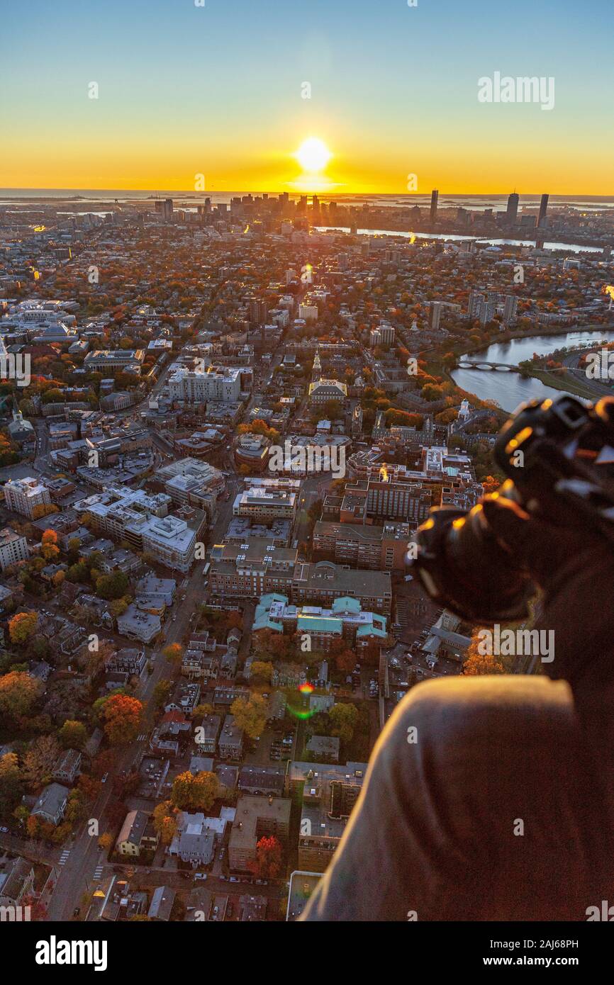 Fotógrafo capturando escenas aéreas desde el helicóptero a medida que el sol se eleva. Foto de stock