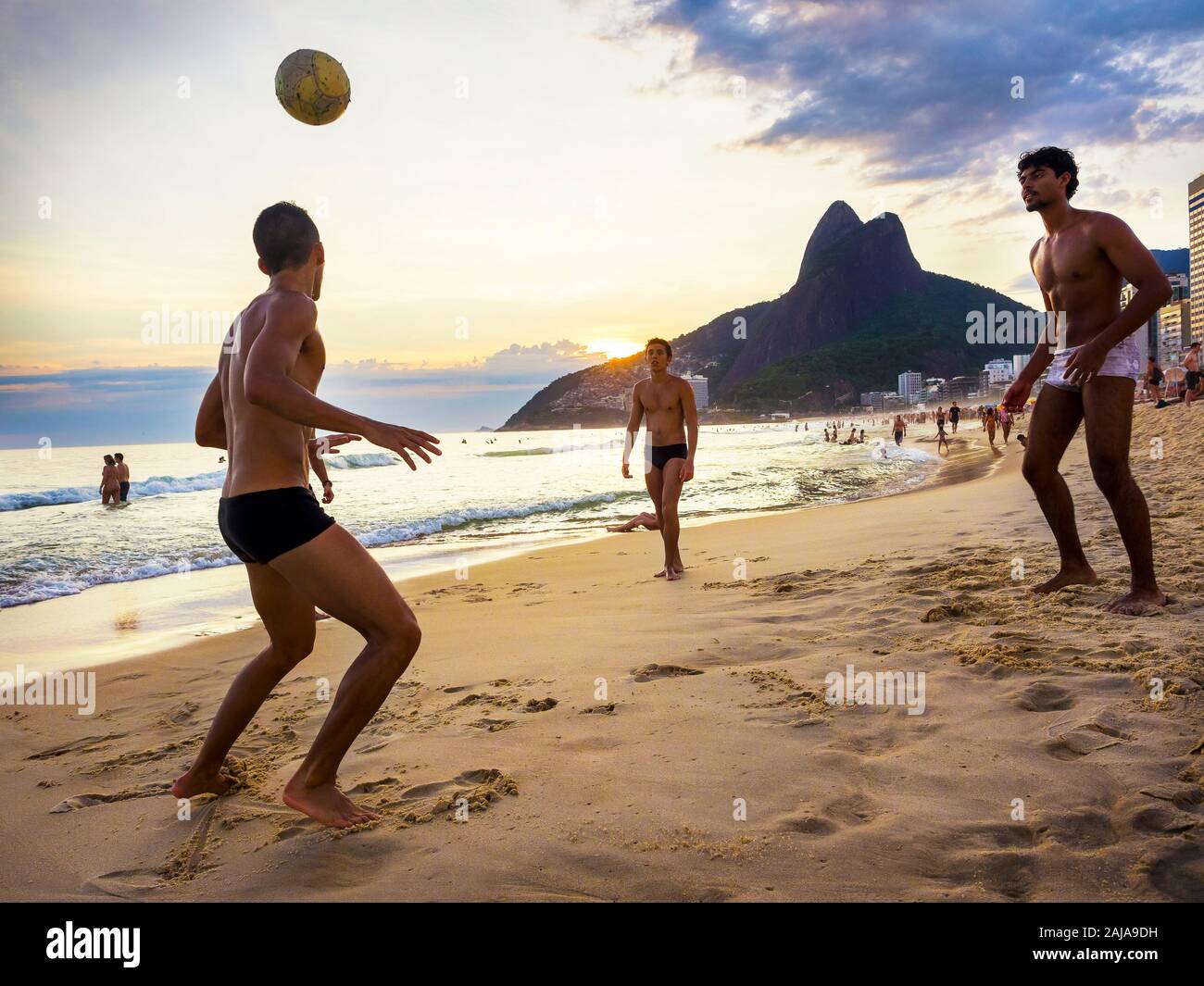 Los lugareños jugando fútbol al atardecer en la playa de Ipanema en Rio de Janeiro, Brasil. Foto de stock