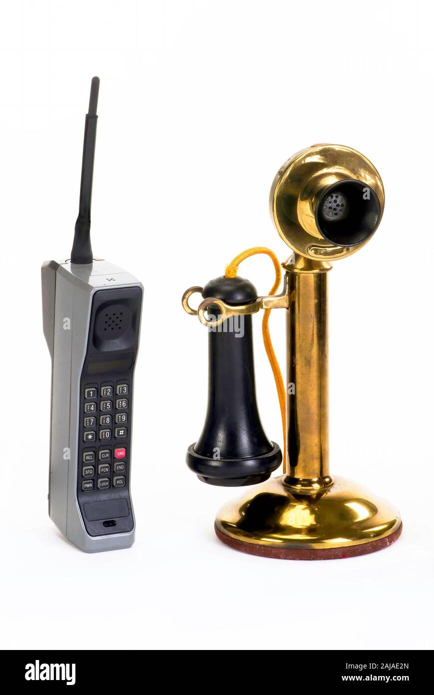 Primer teléfono celular de ladrillo hecha alrededor de 1980, primeros candle stick teléfono hecha alrededor de 1910 . Foto de stock