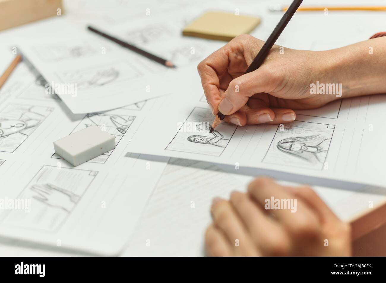 La mano de la mujer dibuja un guión gráfico para una película o una caricatura. Foto de stock