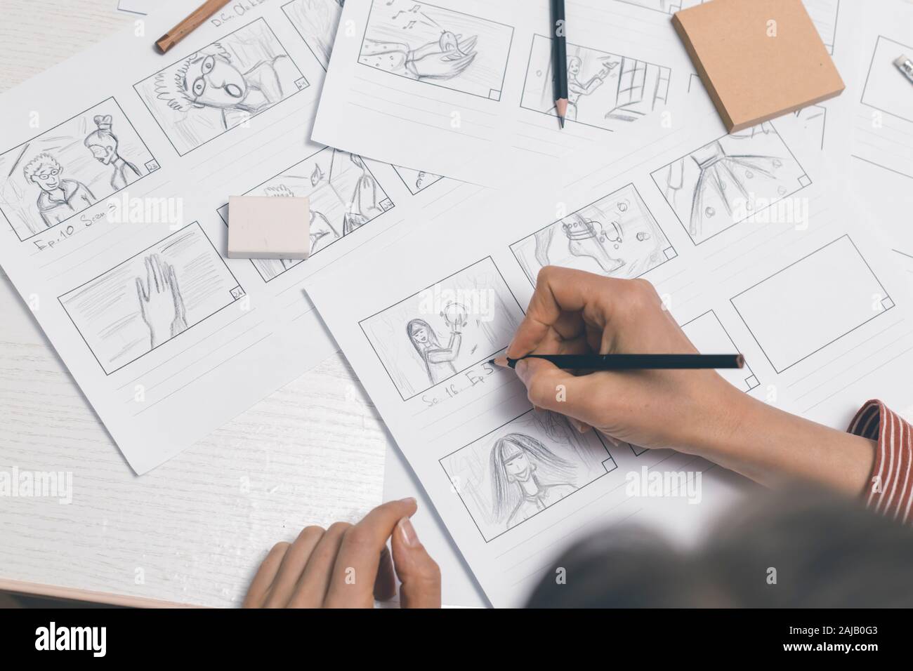 La mano de la mujer dibuja un guión gráfico para una película o una caricatura. Foto de stock