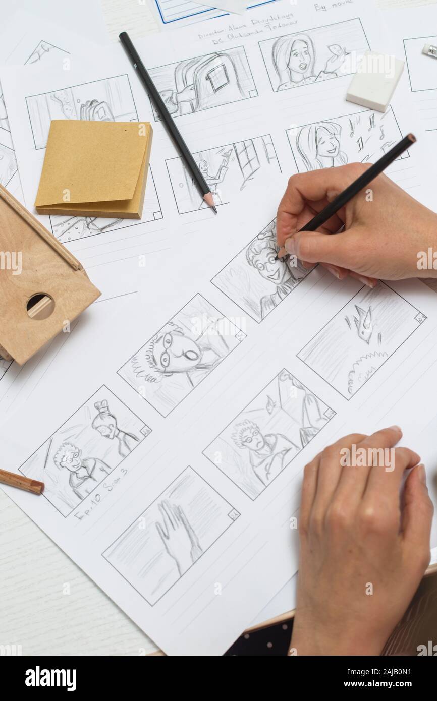 La mano de la mujer dibuja un guión gráfico para una película o una caricatura. Foto de stock