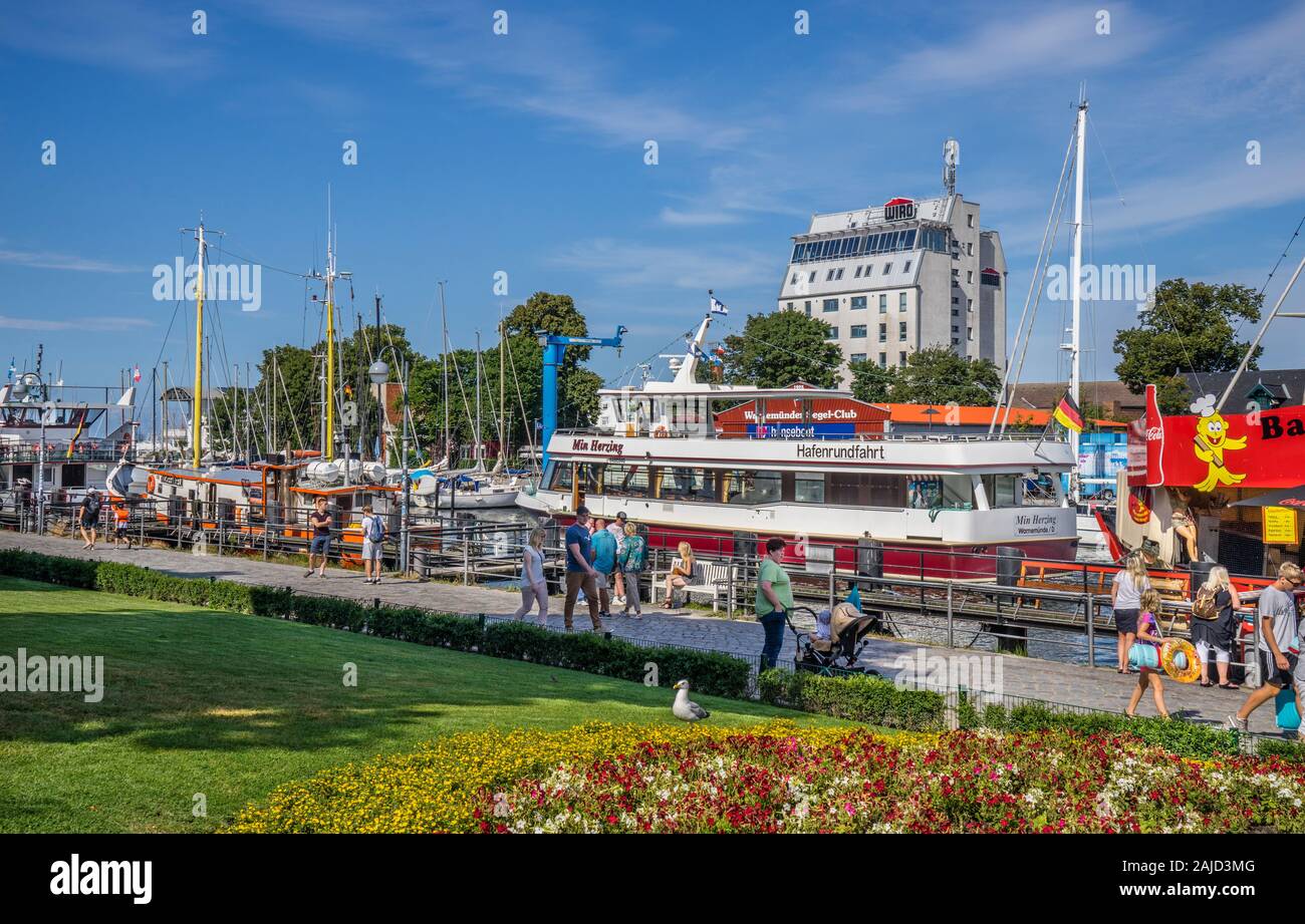 Alter Strom canal, destacada empresa turística con tiendas, crucero por el puerto de botes y barcos de pesca en el Mar Báltico puerto de Warnemünde, Mecklenburg-Vo Foto de stock