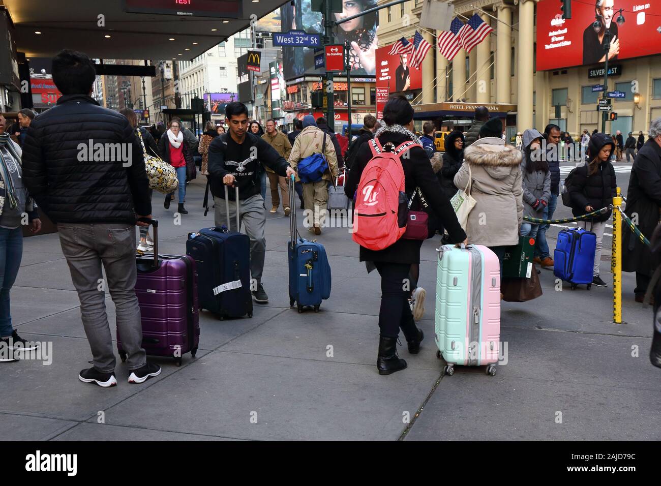 Los turistas con maletas y equipaje rodante en una concurrida calle en  Manhattan, Nueva York, NY Fotografía de stock - Alamy