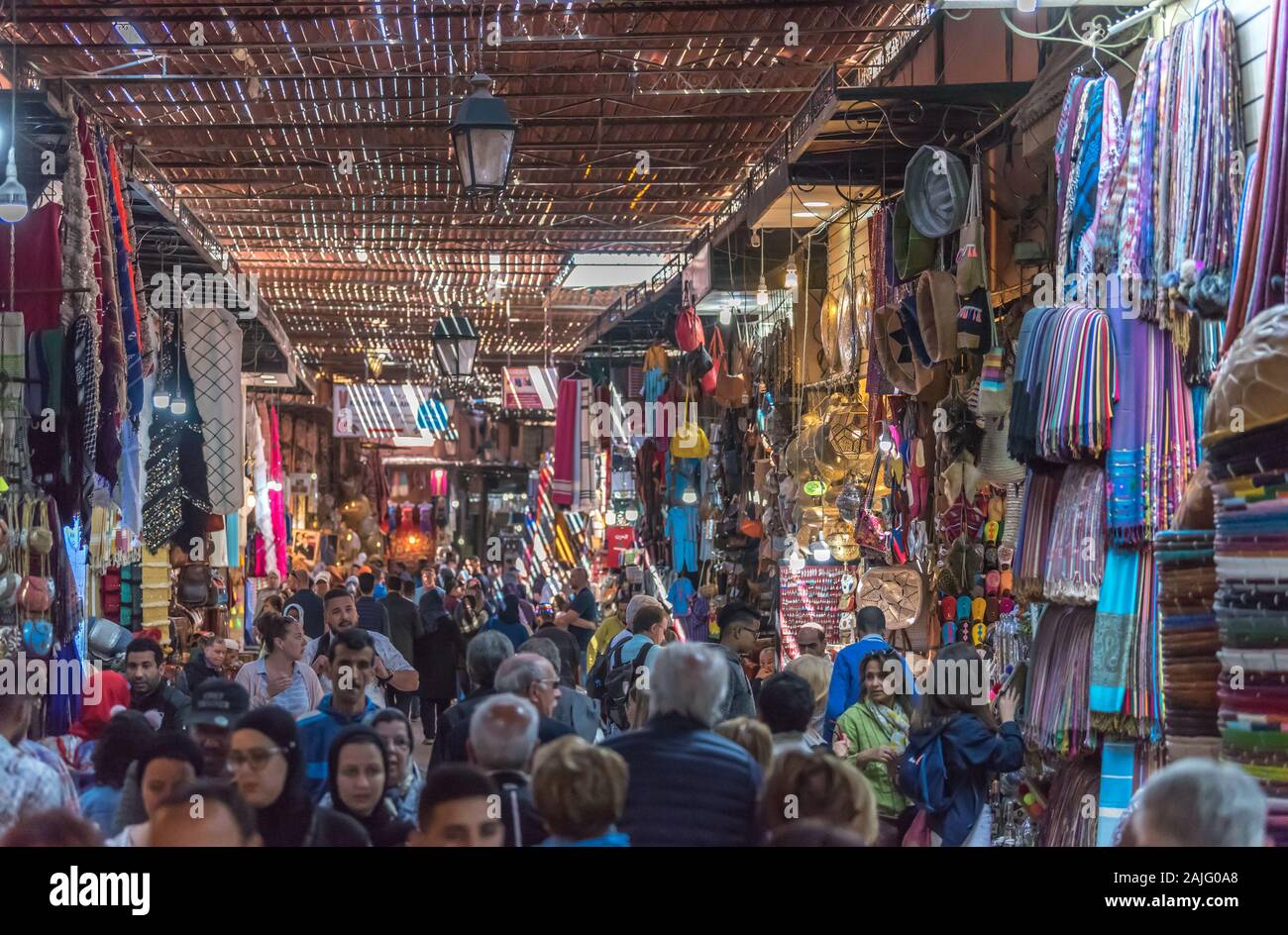 Marrakech, Marruecos: personas y turistas paseando, cabinas y puestos en la callejuela cercana plaza Jemma El Fna, el zoco del mercado dar en la medina de Marrakech, el concurrido bazar Foto de stock