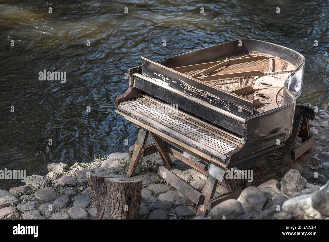 Abandonó gran piano, piano arruinada por un río Vilnia (banco) en el barrio de artistas Uzupis en Vilnius, Lituania, ambiente bohemio. República de Uzupis Foto de stock