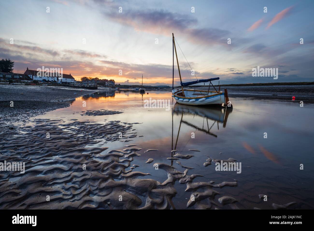 Puesta de sol sobre el puerto de Burnham Overy Staithe en la marea baja Foto de stock