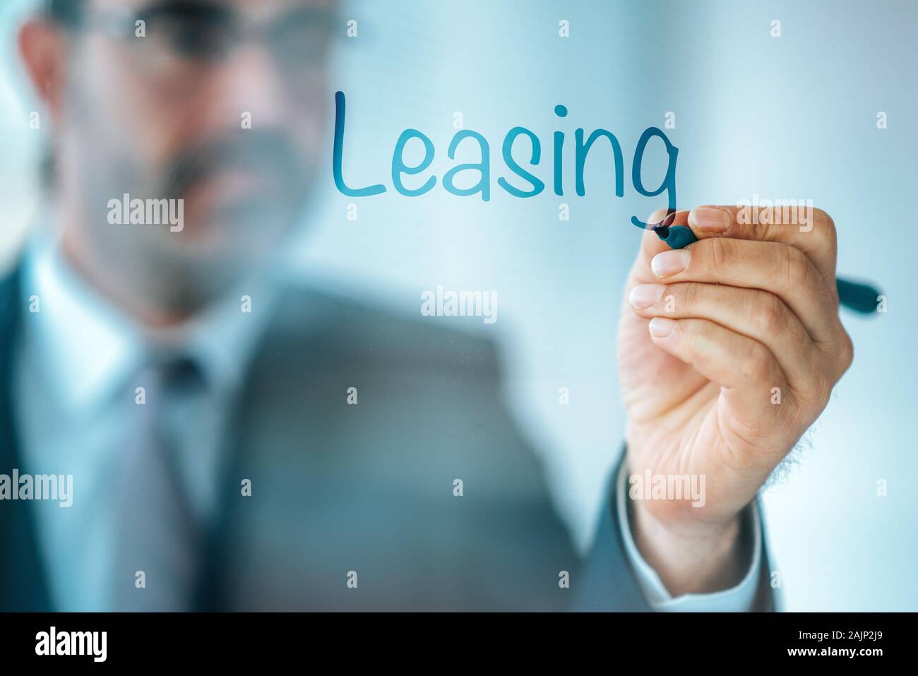 Empresario escriba la palabra Leasing y dar una breve propiedad, edificios, vehículos son bienes comunes que son arrendados Foto de stock