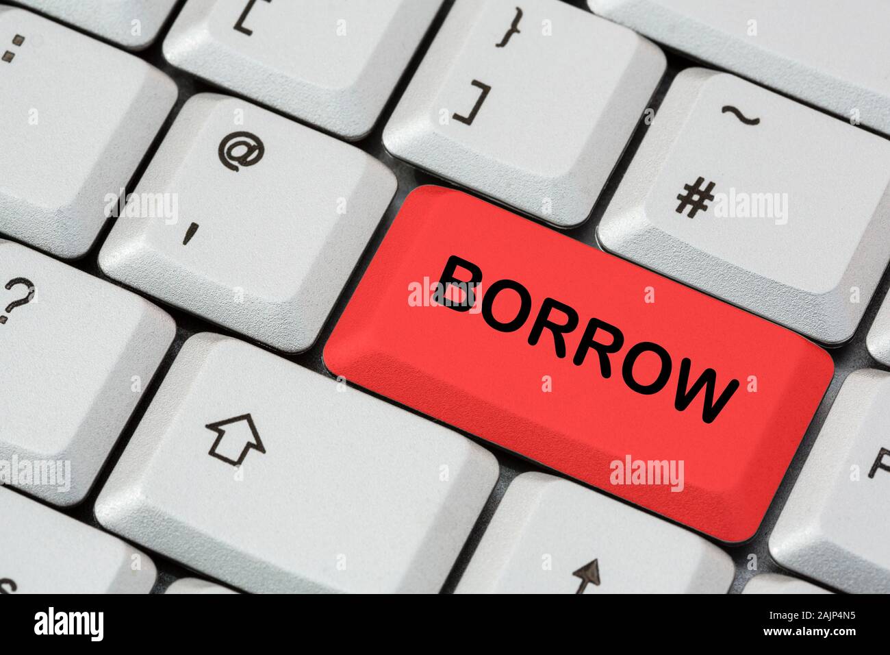 Un teclado con la palabra BORROW escrita en letras negras en la tecla ENTER roja. Concepto de deuda y dinero en préstamo. Inglaterra, Reino Unido, Gran Bretaña Foto de stock