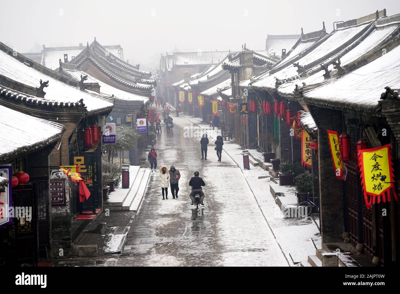 Pingyao, China. 5 de enero, 2020. Los turistas visitan el nevado Pingyao Antigua ciudad en el norte de la Provincia china de Shanxi, 5 de enero de 2020. Fundada en el siglo 14, la antigua ciudad de Pingyao es un ejemplo excepcionalmente bien conservado de una ciudad chinos tradicionales, que fue nombrada Patrimonio de la Humanidad por la UNESCO en 1997. Crédito: Zhan Yan/Xinhua/Alamy Live News Foto de stock