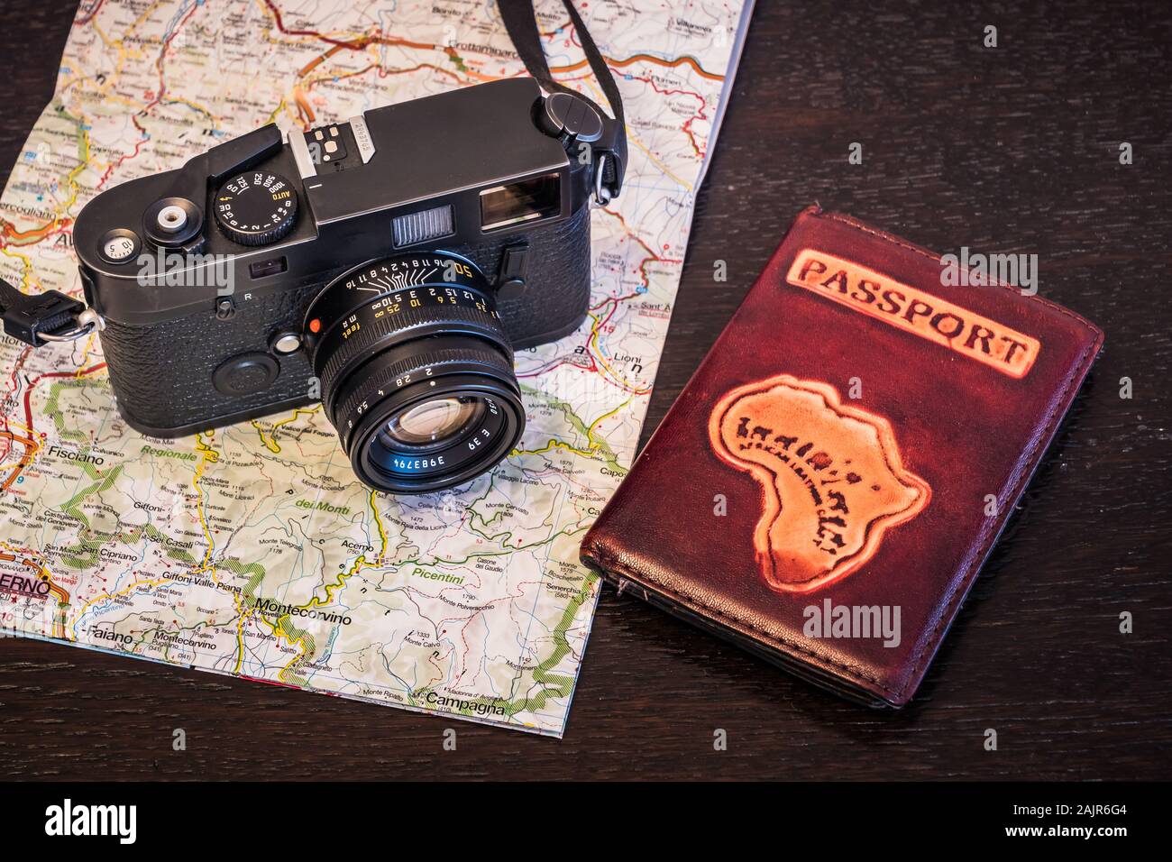 Fotografía de viajes concepto - cámara fotográfica, Pasaporte y mapa sobre un fondo de madera oscura - Aspecto Vintage Foto de stock