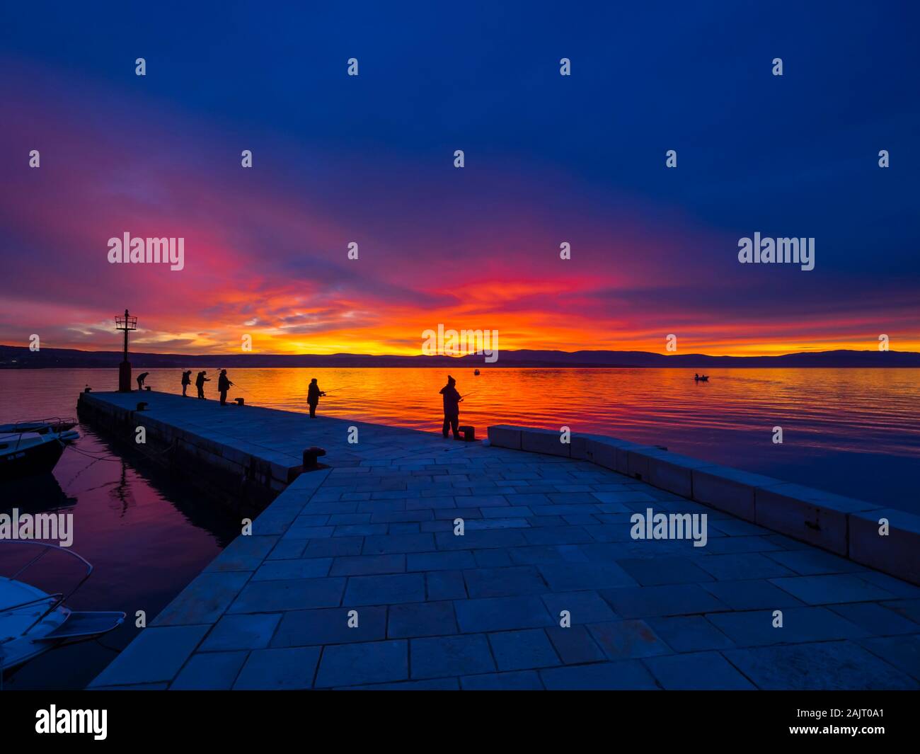 Los pescadores antes del atardecer paisaje en pequeño y tranquilo puerto en Malinska en Croacia Foto de stock