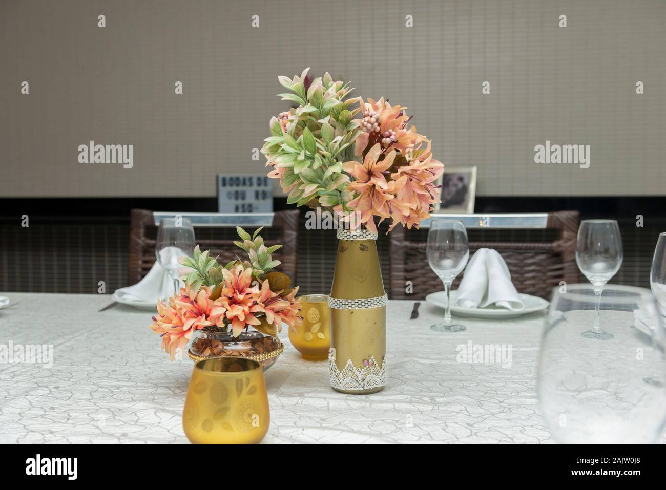 Flores decorativas en hermoso jarrón sobre una mesa de comedor junto a una vela. Decoración sencilla de aniversario de boda. Área de texto. Copie el espacio foc selectiva Foto de stock