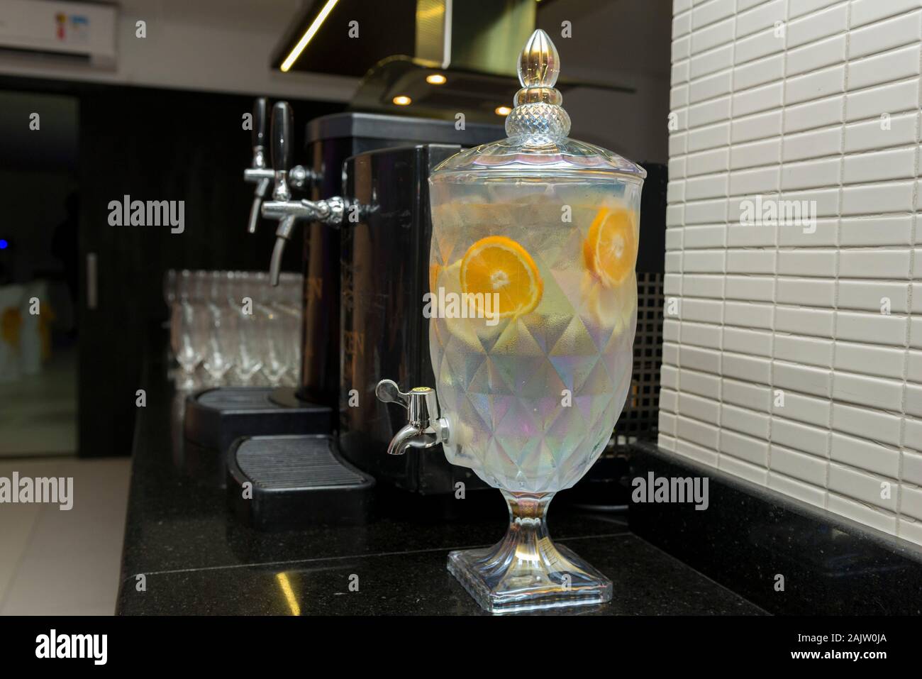 Decantador de cristal hermosas con agua saborear con frutas tropicales  junto a una hielera con cerveza y gafas Fotografía de stock - Alamy