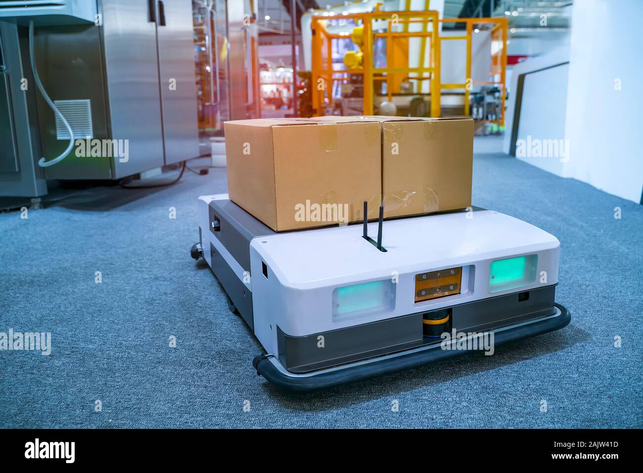 Almacén coche robot lleva caja de cartón ensamblado en la fábrica. Foto de stock