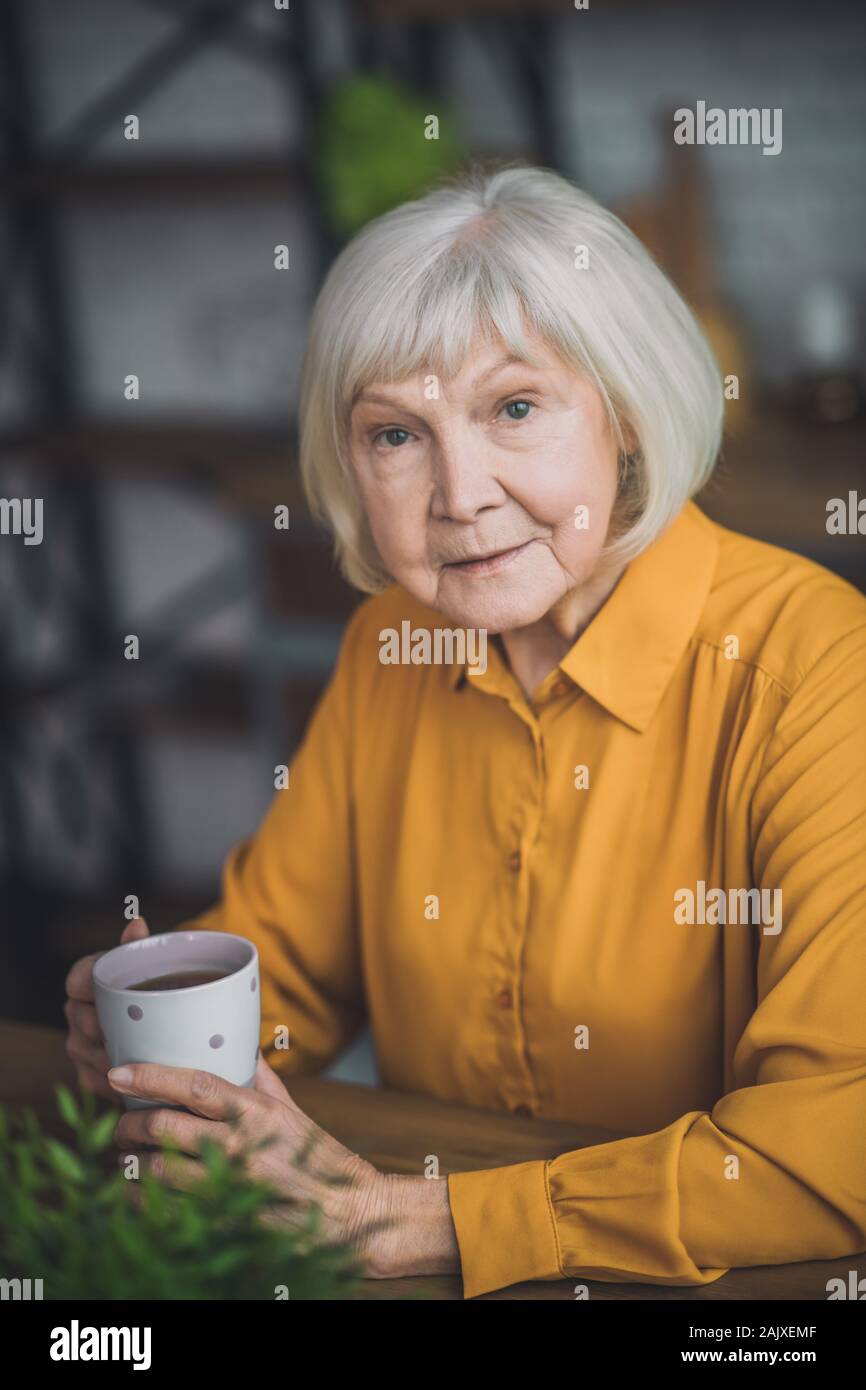 Buena anciana en amarillo sensación maravillosa Foto de stock