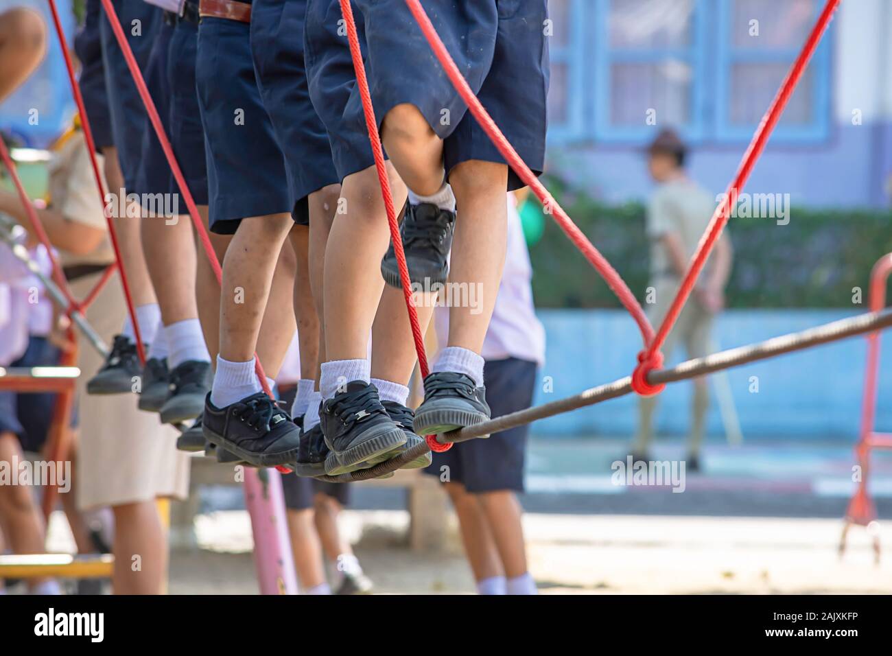 Los niños caminando sobre la cuerda de cable están realizando la actividad. Foto de stock