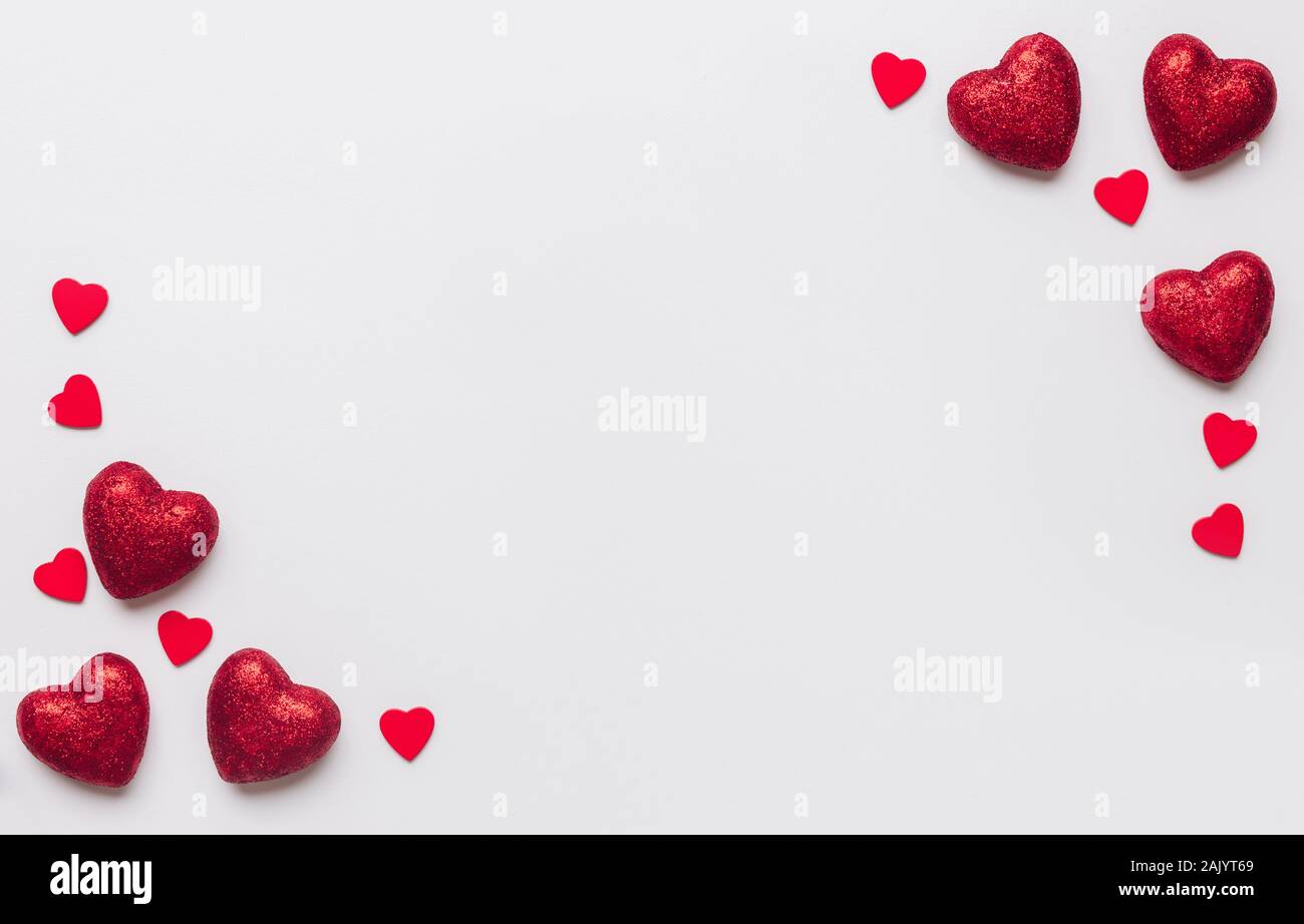 Stock photo de grandes y pequeños corazones rojos sobre fondo blanco. Corazones en las esquinas con un espacio para texto Foto de stock