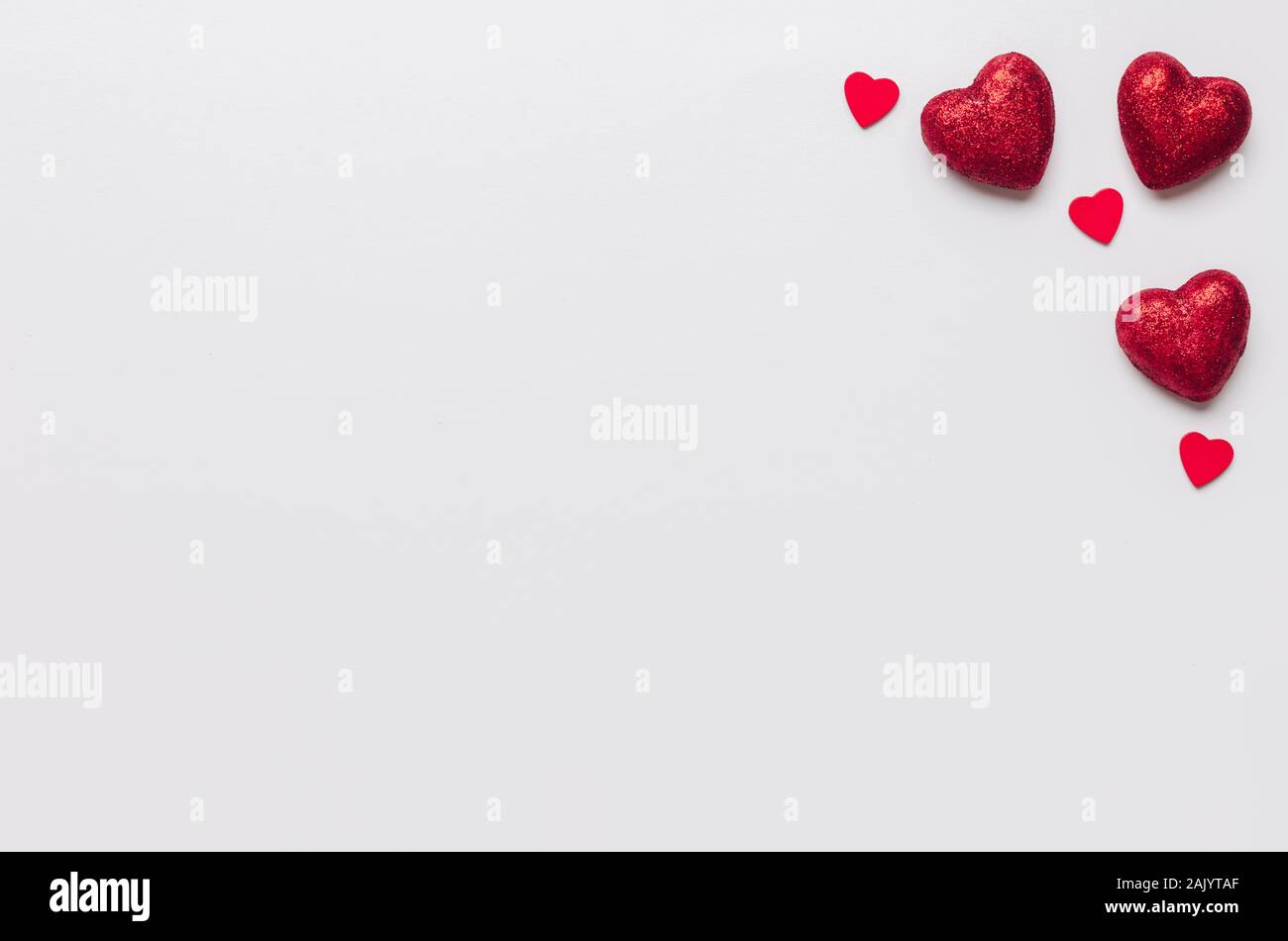 Stock photo de grandes y pequeños corazones rojos sobre fondo blanco. Corazones en las esquinas con un espacio para texto Foto de stock