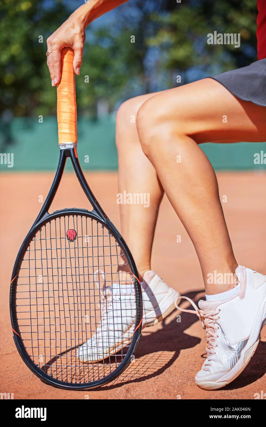 Jugador de tenis femenino seet en el terreno de la corte en el día. Foto de stock