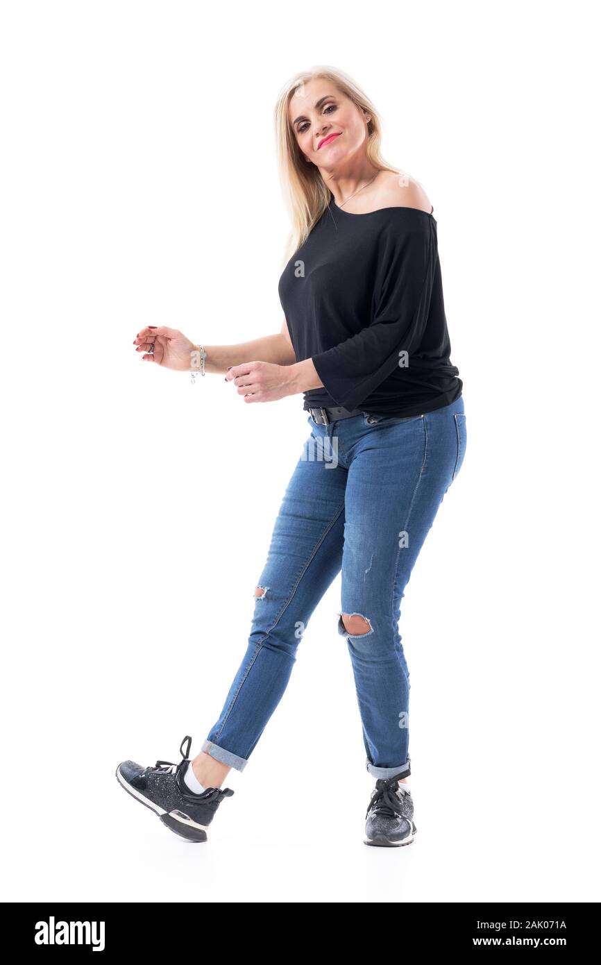 Edad media femenina mujer moderna bailando despreocupada en ropa casual con  jeans y zapatillas. Longitud de cuerpo completo aislado sobre fondo blanco  Fotografía de stock - Alamy