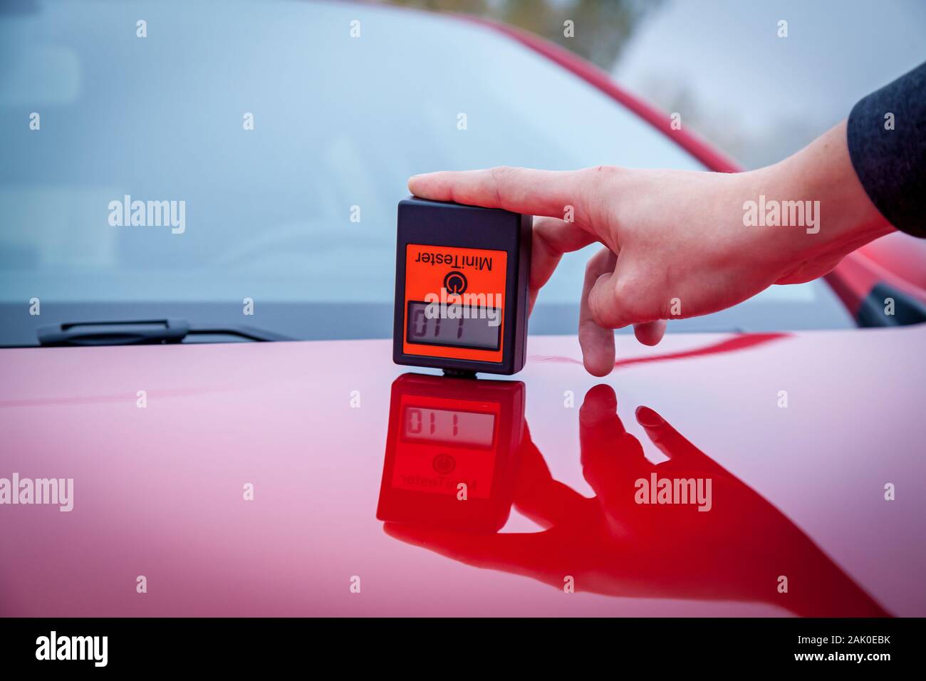 Medir el espesor de la capa de pintura de coches color rojo usando un  medidor de espesor de pintura Fotografía de stock - Alamy
