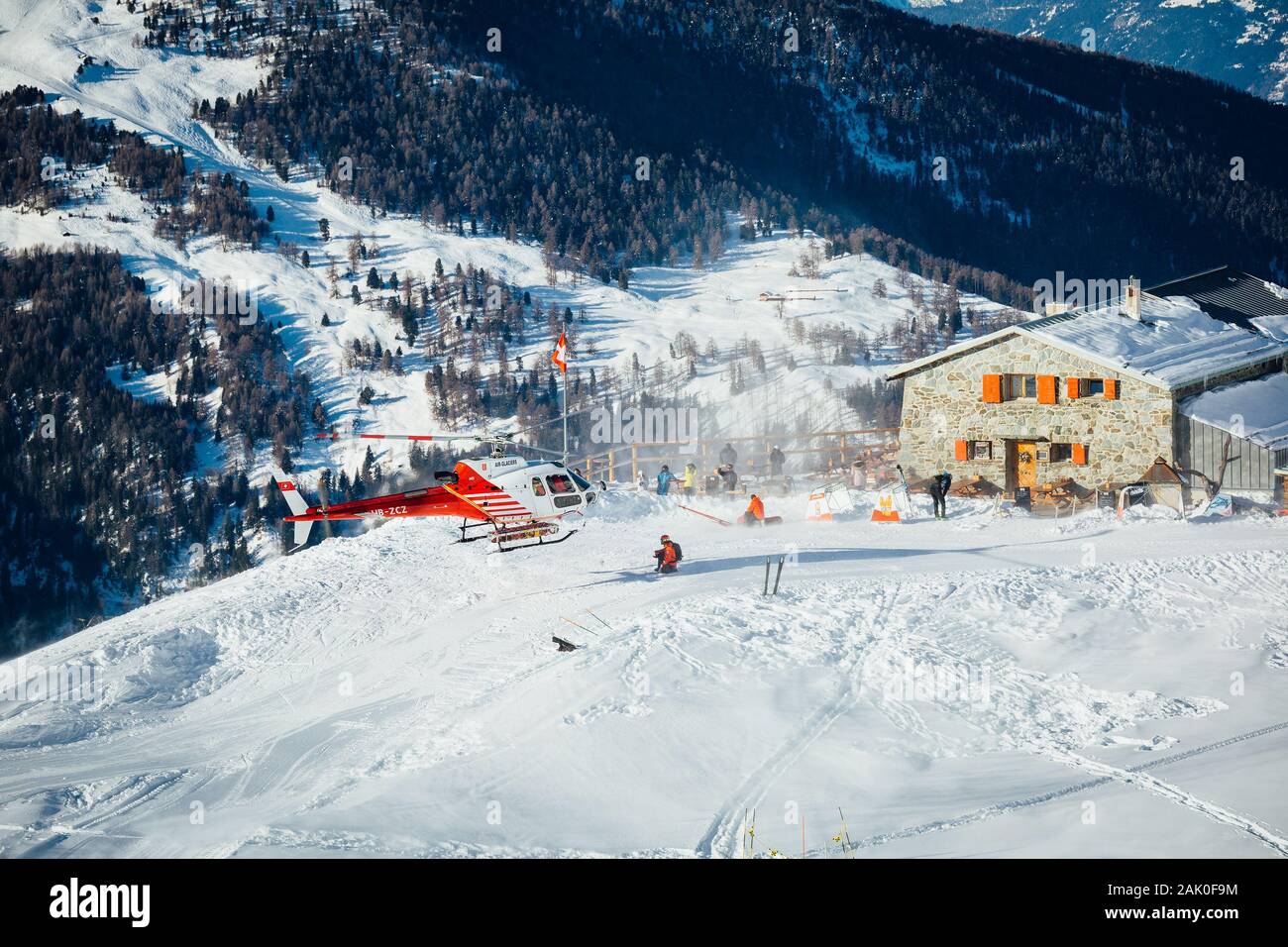 St Luc, Suiza - 30 de diciembre de 2019: rescate de montaña suizo helicóptero despegaba después de recoger heridos esquiador en una estación de esquí de los Alpes Suizos. Foto de stock