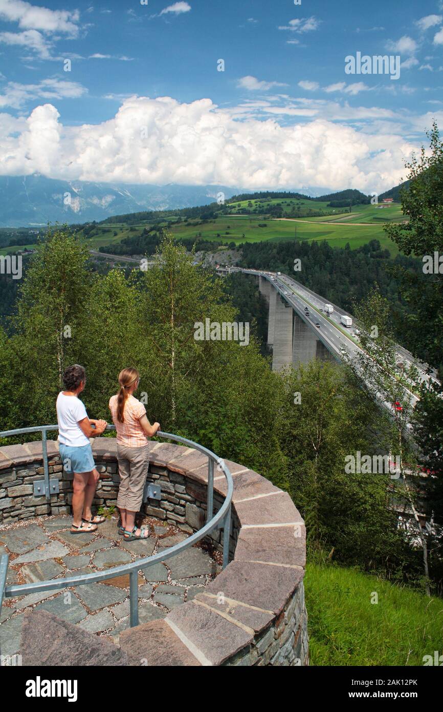 Dos mujeres en el mirador miran el puente sobre el valle - Paso de Brenner Foto de stock