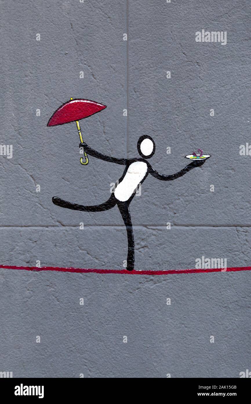 Arte en la calle de una figura en equilibrio sobre una línea, sosteniendo paraguas y plato, Palma de Mallorca, España Foto de stock