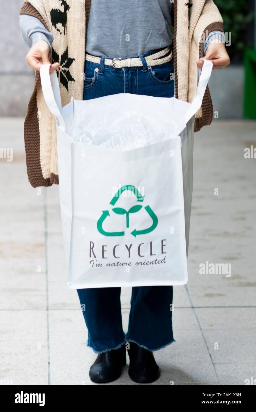 Mujer teniendo en botellas de plástico con bolsa de ecología reciclar shop Foto de stock