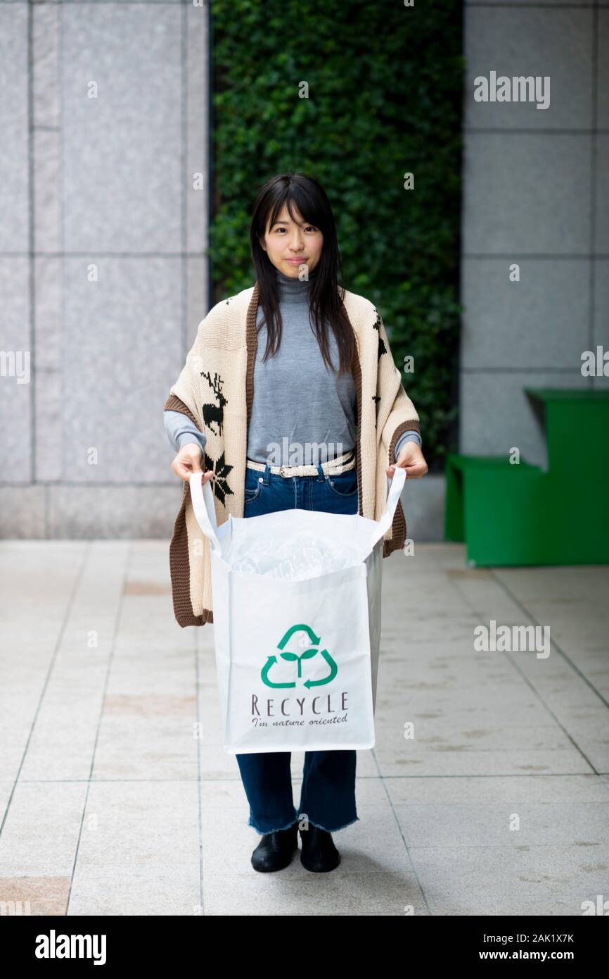 Mujer teniendo en botellas de plástico con bolsa de ecología reciclar shop Foto de stock