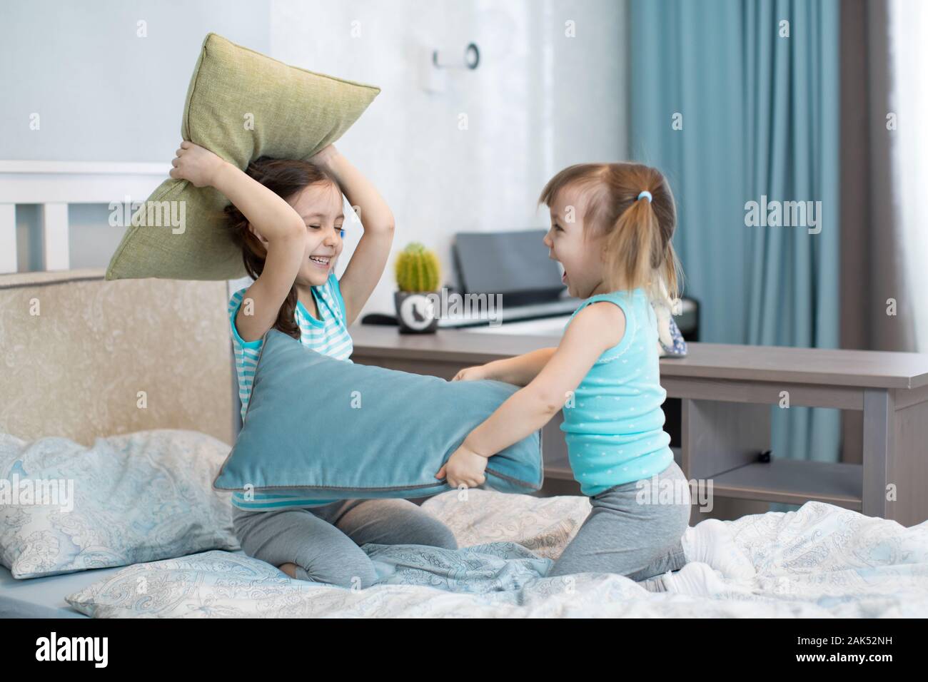 Chiquillos niñas juegan con almohadas en dormitorio Foto de stock