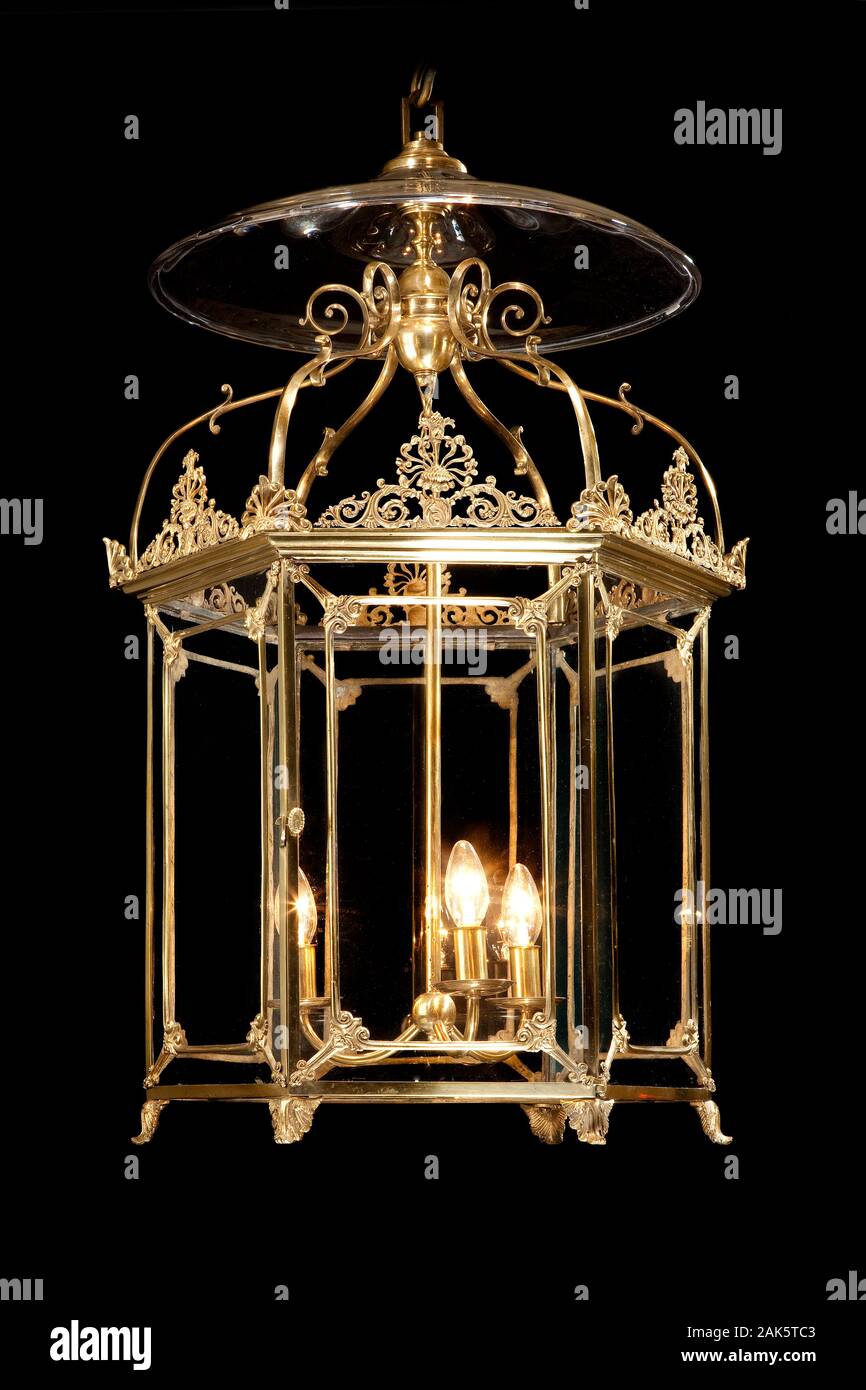 Latón colgantes decorativos antiguos lámpara linterna iluminando aislados en negro Fotografía de stock - Alamy
