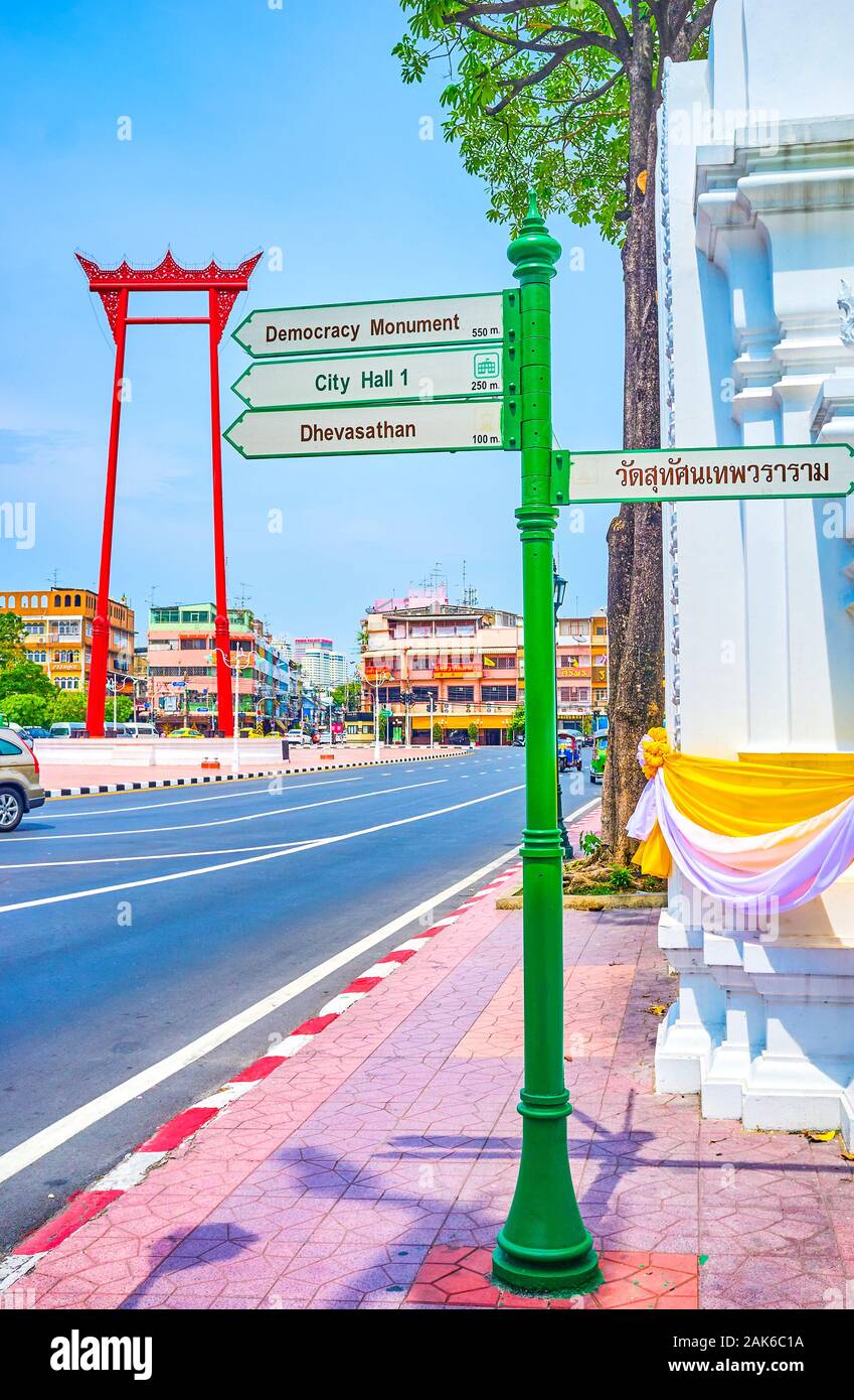BANGKOK, TAILANDIA - Abril 15, 2019: la calle cartel señales en dirección a diversas atracciones de la ciudad, se encuentra en la plaza con gigantescas alas en el backg Foto de stock