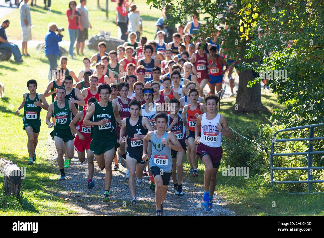 Wappingers Falls, Nueva York, Estados Unidos - 29 de septiembre de 2019: el pack de plomo de los muchachos redondeando un rincón durante una carrera de cross country high school. Foto de stock