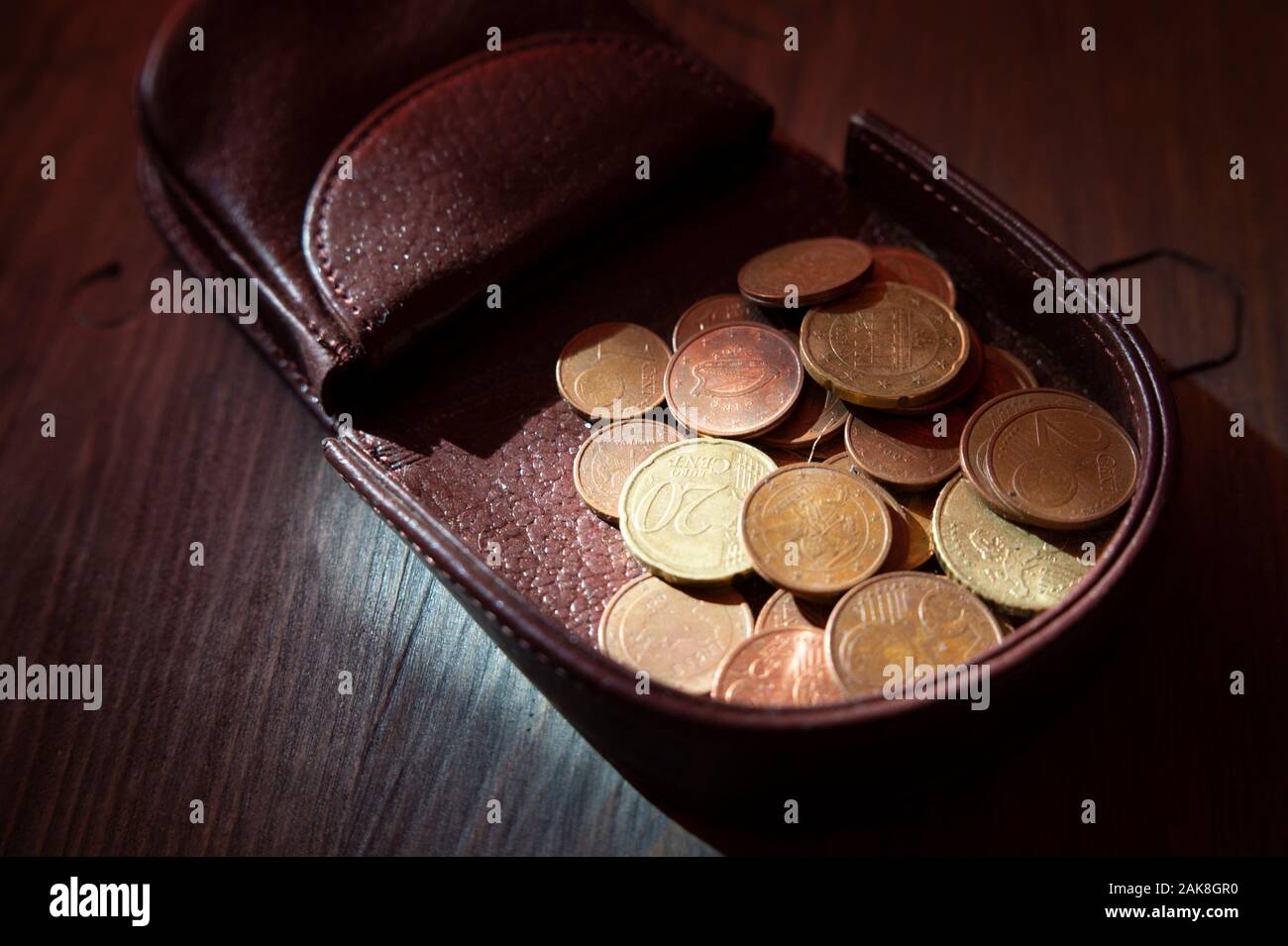 Cambio de monedas en euros en abrir duro cuero marrón oscuro caso de moneda  bandeja bolso o cartera, visto de cerca en una tabla de madera Fotografía  de stock - Alamy