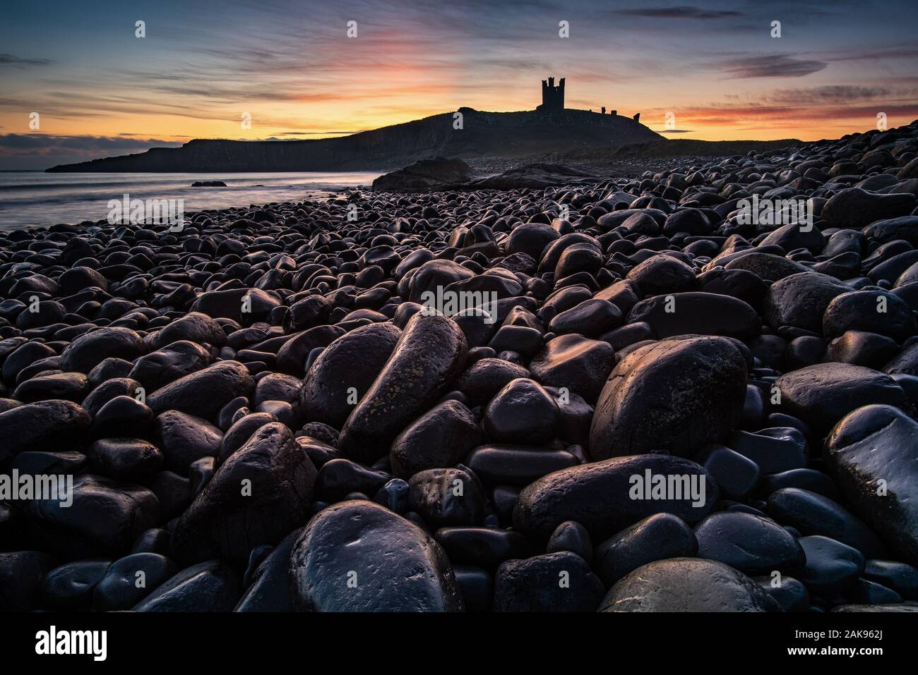 Castillo de Dunstanburgh en Northumberland, Inglaterra. El Castillo, ahora una ruina, ocupa una posición prominente en la Bahía Embleton, Northumberland, Inglaterra. Foto de stock