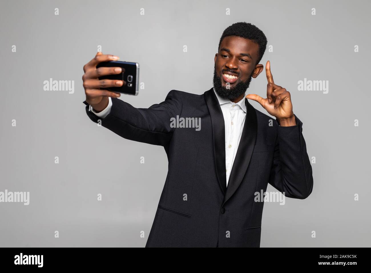 Feliz guapo joven empresario africano teniendo selfie Foto de stock