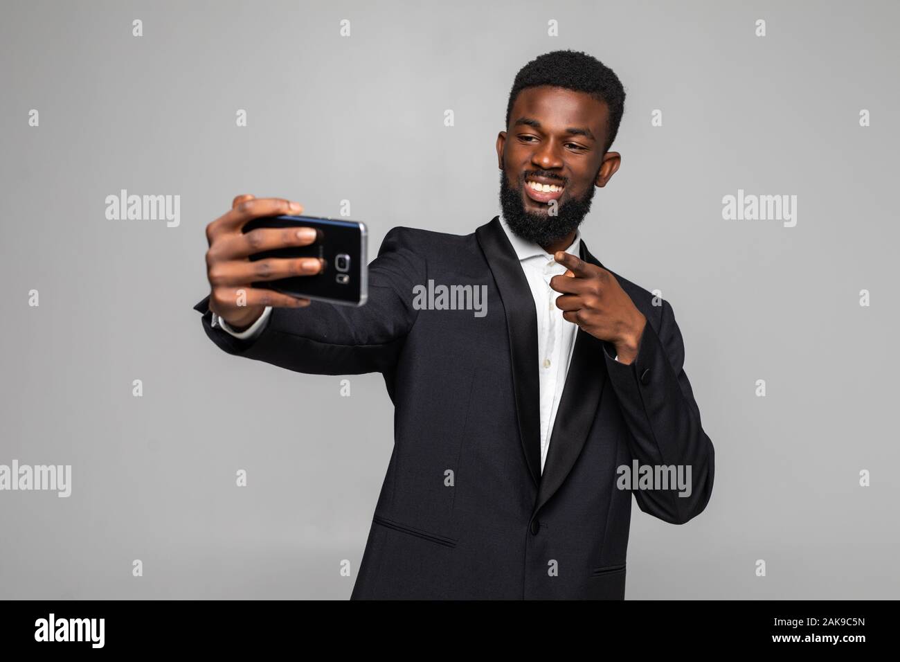 Feliz guapo joven empresario africano teniendo selfie Foto de stock