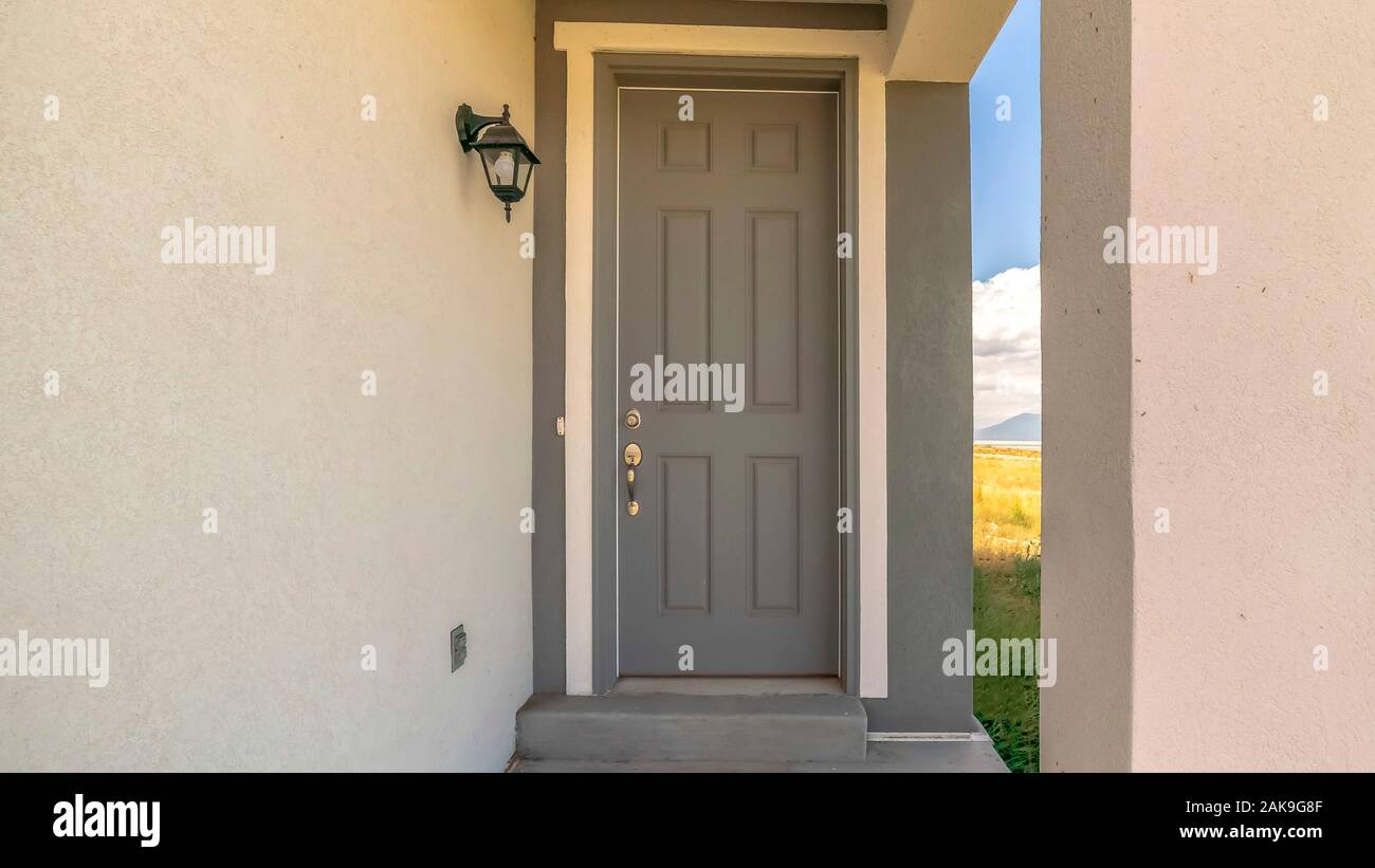 Pano cerca de casa entrada con puerta frontal gris y linterna sobre el muro  de hormigón Fotografía de stock - Alamy