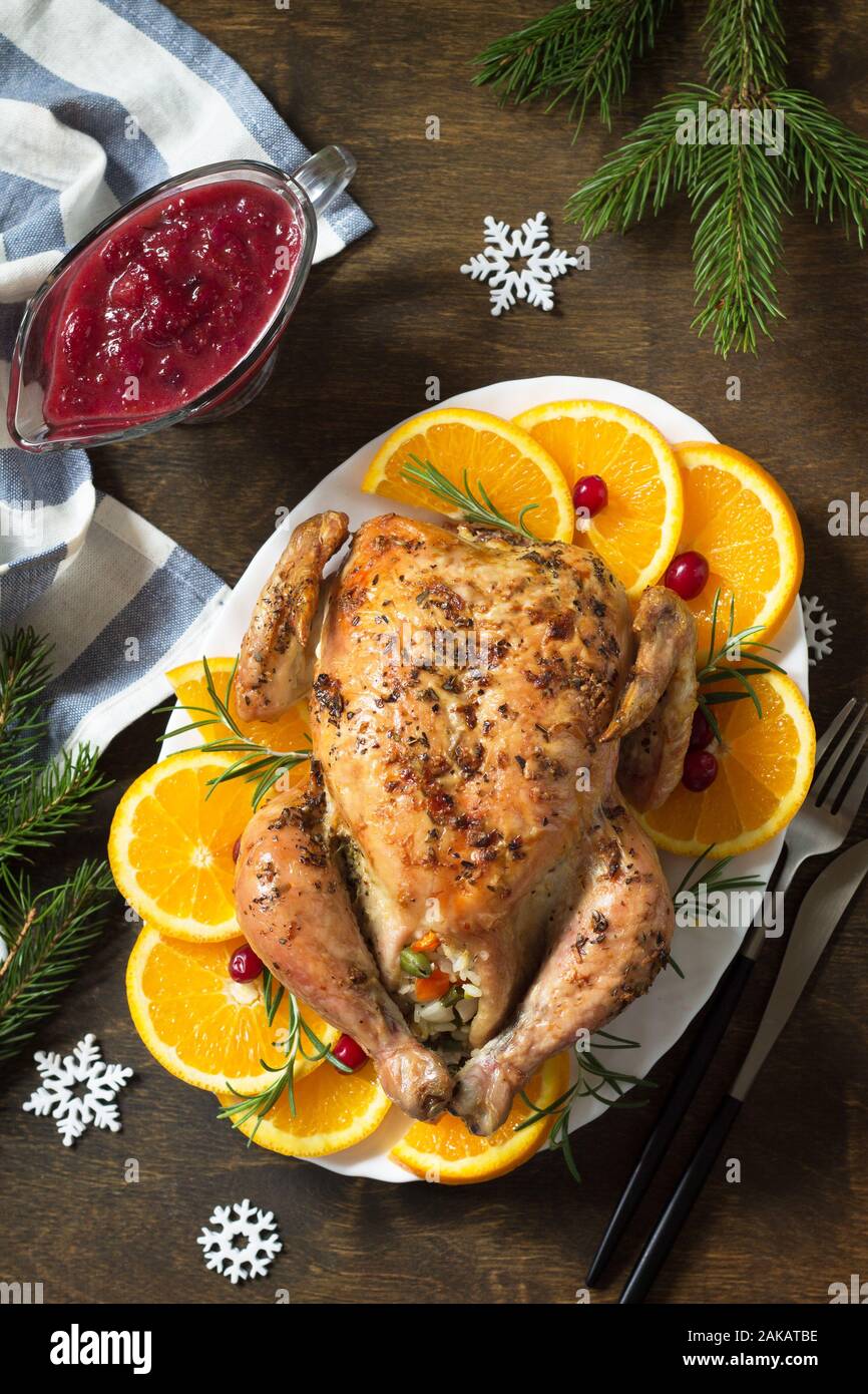 Concepto de Navidad o cena de Año Nuevo pavo asado relleno con arroz y salsa de arándano sobre la mesa de madera. Vista desde arriba. Foto de stock