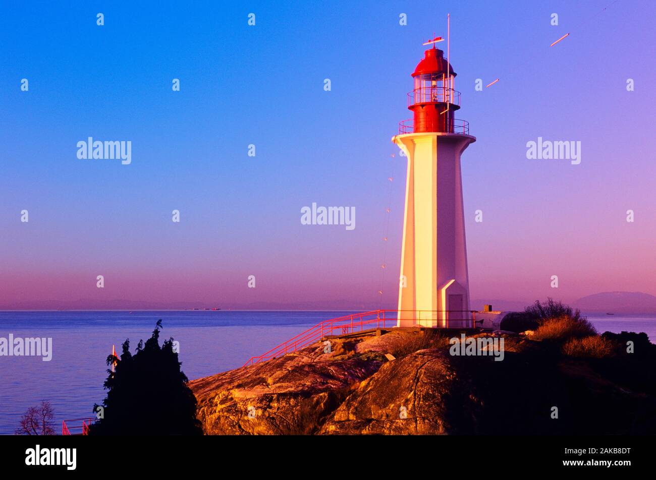 Faro en la orilla al atardecer, el Faro Park, Vancouver, British Columbia, Canadá Foto de stock