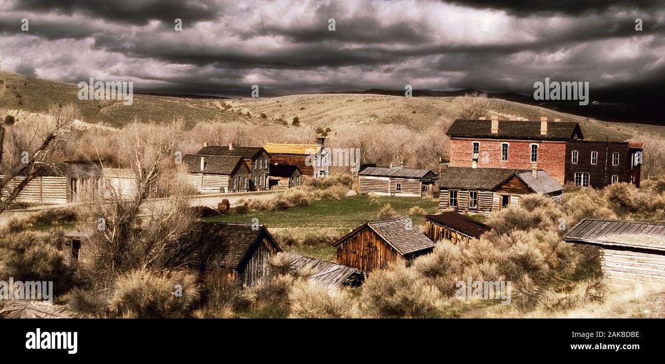 Casas en ciudad fantasma bajo el espectacular cielo, Parque Histórico Estatal Bannack, Montana, EE.UU. Foto de stock