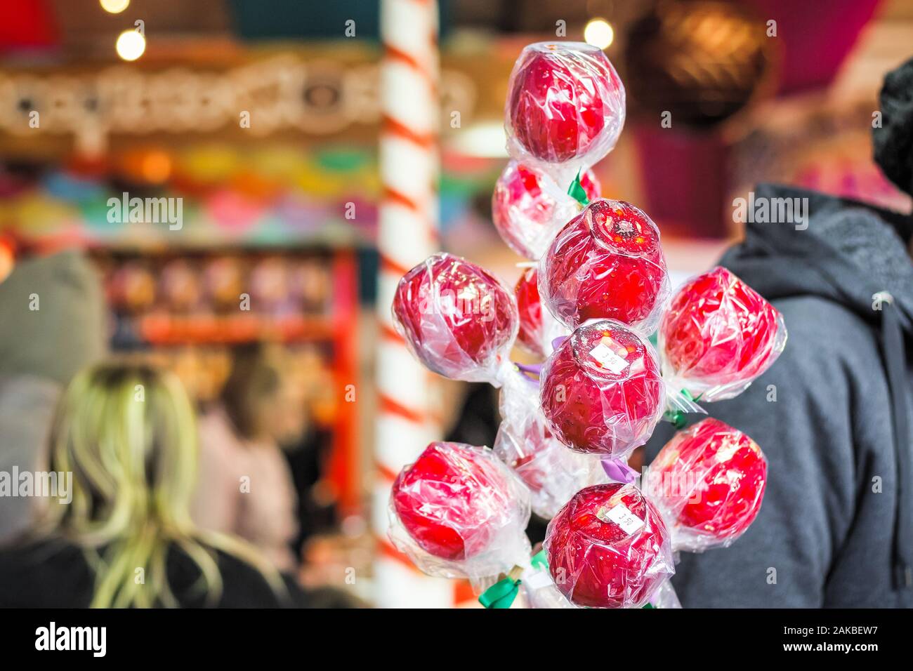 Las manzanas de caramelo envuelto en exhibición en el mercado de Navidad en el país de las maravillas invernal de Londres Foto de stock