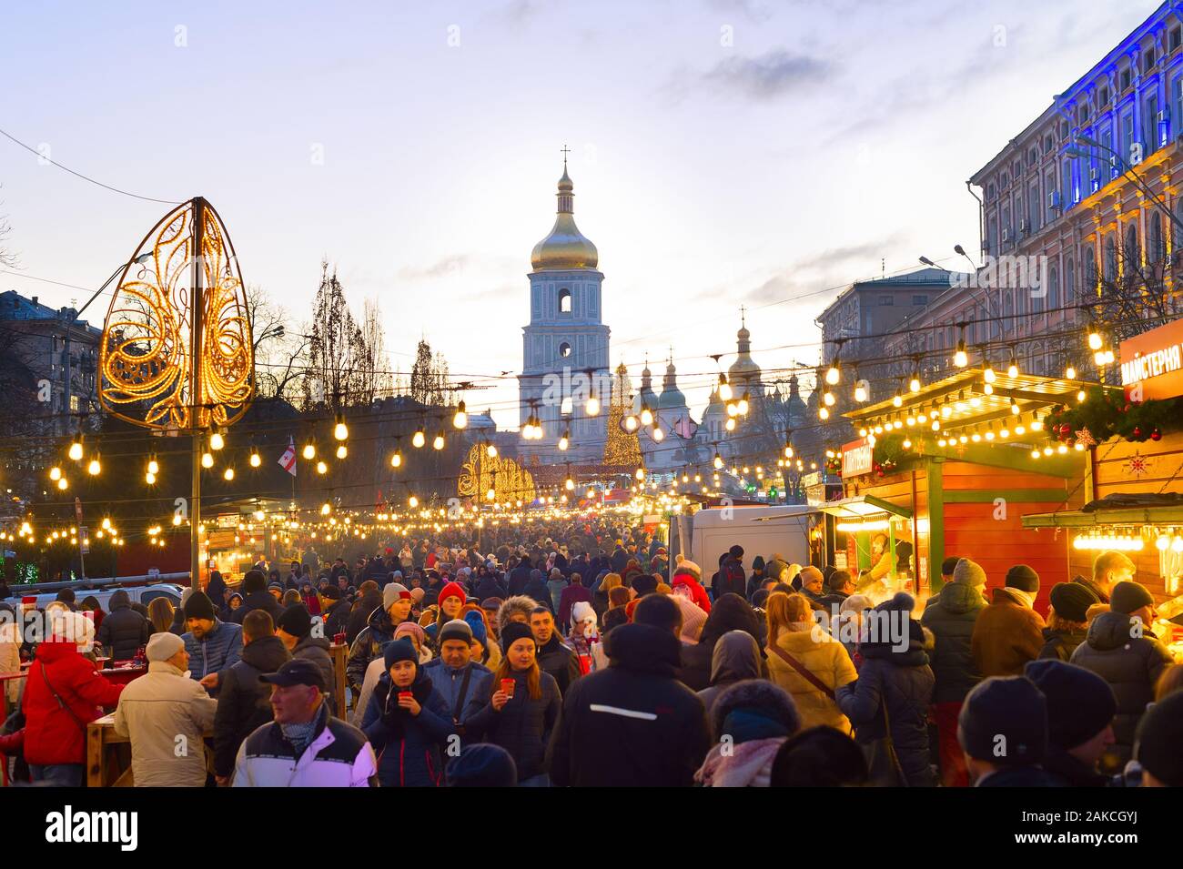 KIEV, Ucrania - Enero 06, 2020: Las personas que asistan a los mercados de Navidad y Año Nuevo en el casco antiguo de la ciudad de Kiev, con la Catedral de Sofía en el fondo Foto de stock