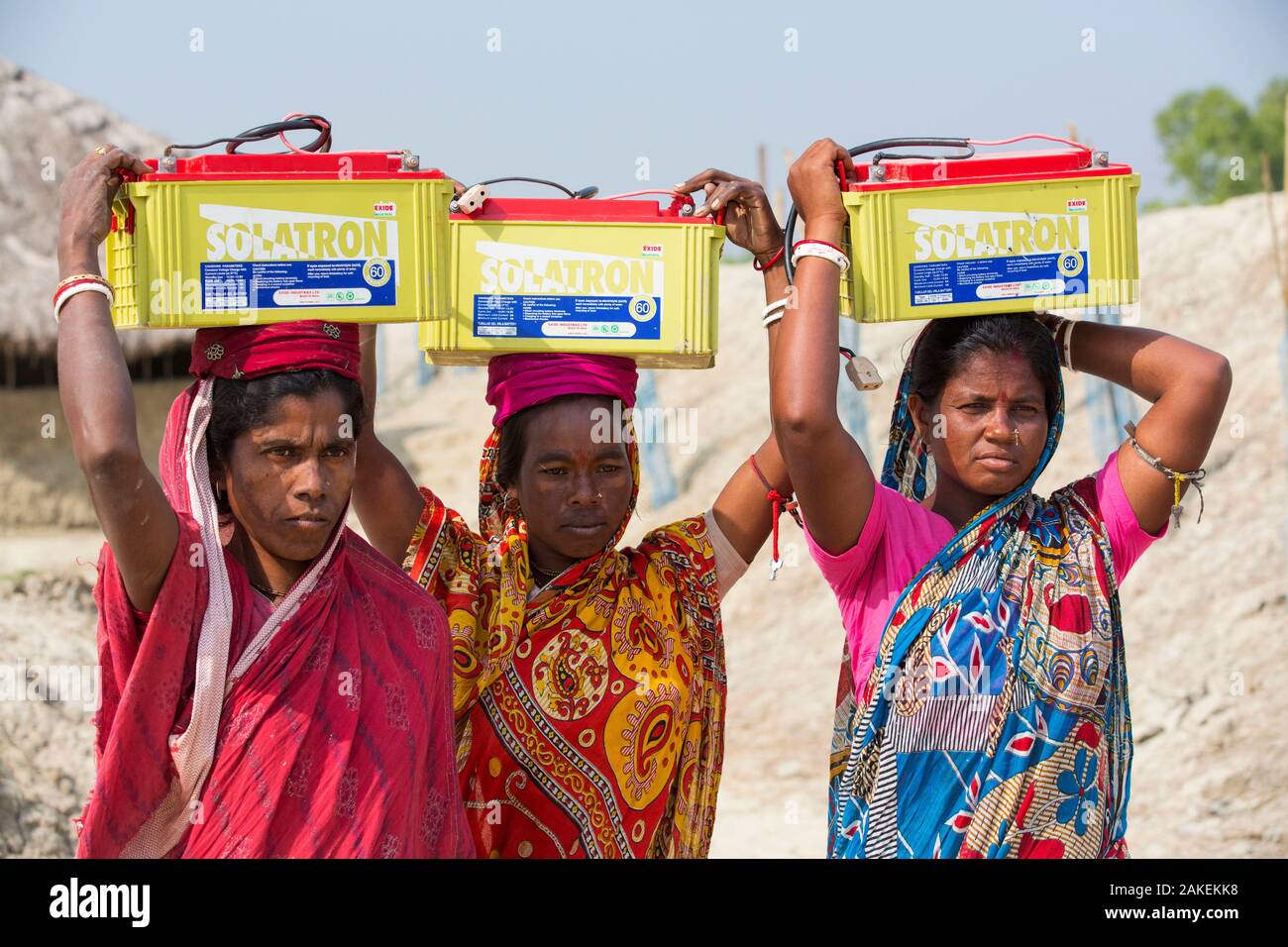 Las mujeres recogían las pilas cargadas de energía solar del proyecto WWF para suministrar electricidad a una remota isla en Sunderbans, Delta del Ganges, en la India. Diciembre de 2013 Foto de stock
