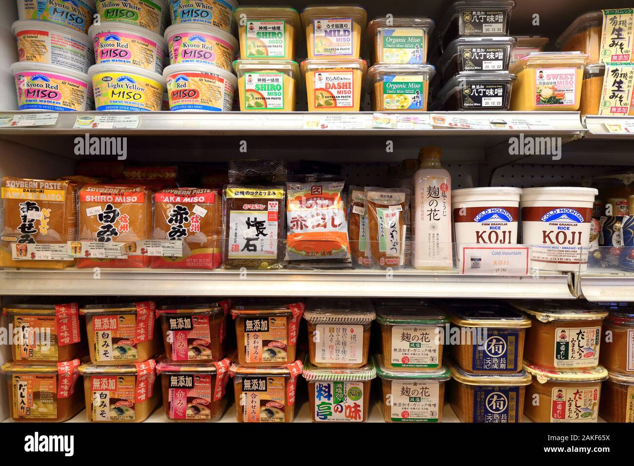 Diferentes marcas de pasta miso y pasta de soja fermentada en un estante del refrigerador en un supermercado japonés-americano Foto de stock